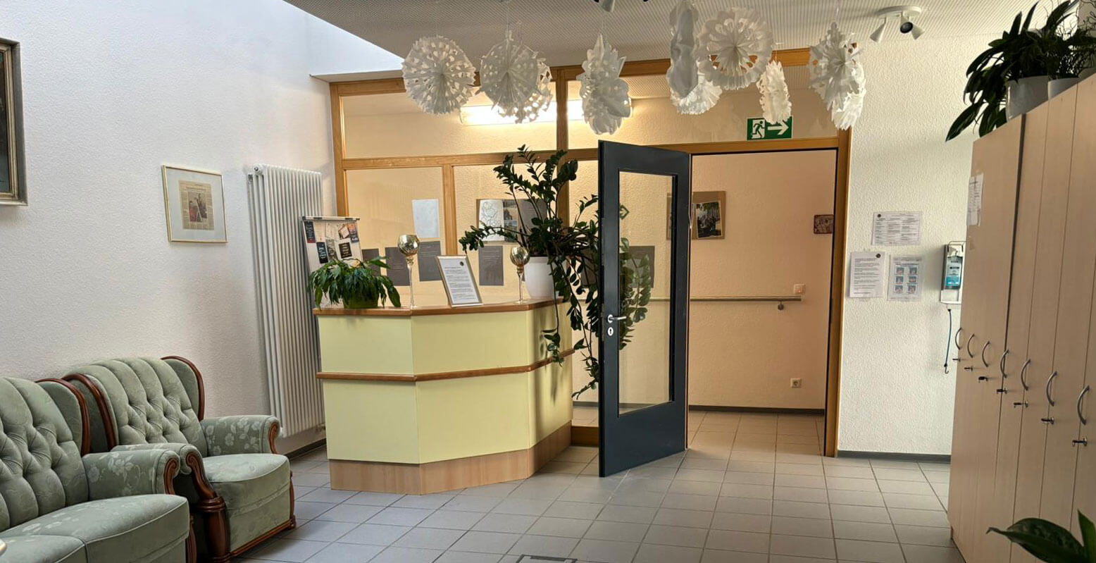 Empfangsbereich mit Tresen, Sofas und Schließfächern